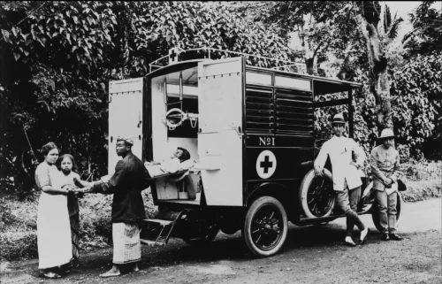 Potret pasien Eropa dimasukkan ke mobil ambulans di Hindia-Belanda.